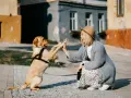 Szczeniak i kobieta dają sobie piątkę, pokazując, jak bawić się ze szczeniakiem. Radosna interakcja na tle miejskich kamienic.
